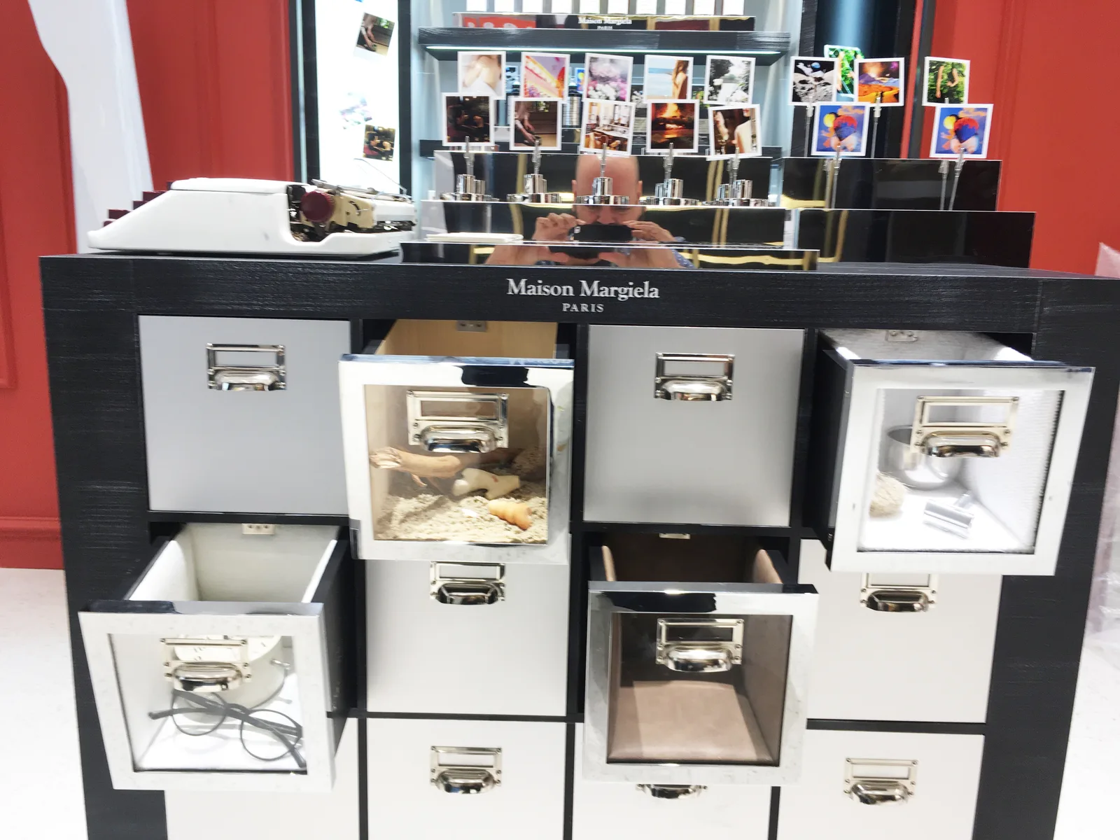 Mueble de cajones de Maison Margiela abiertos, con objetos distintos dentro de cada cajón
