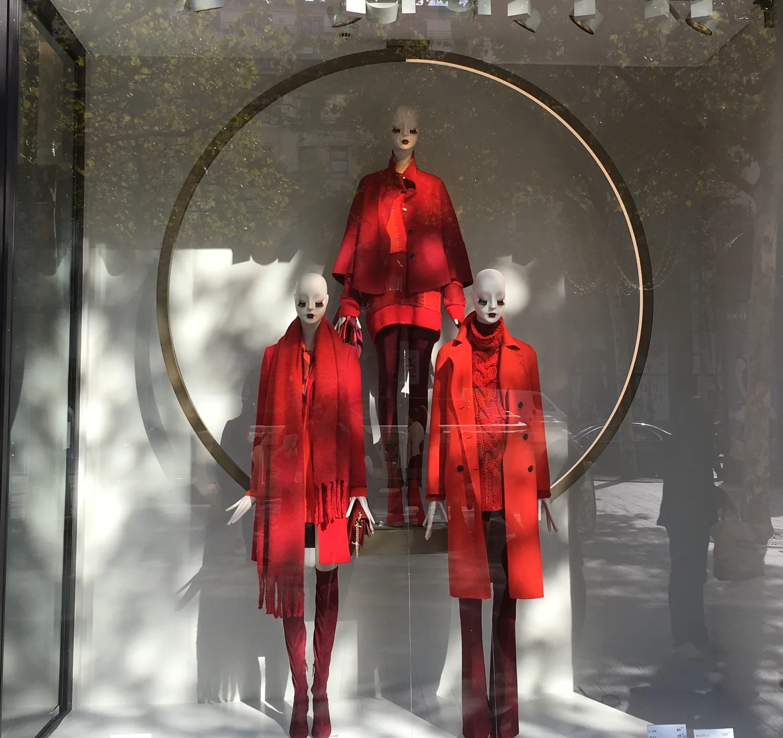 Escaparate de Zara en París con tres maniquíes vestidos de rojo delante de un gran aro