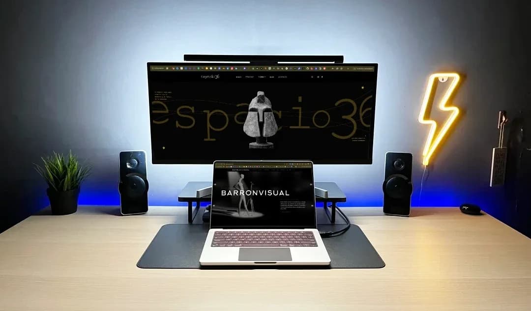 Desk with the espacio36 website on the monitor and the BARRONVISUAL website on the laptop